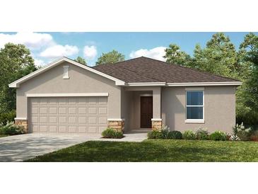 Charming one-story home showcasing a two-car garage, neutral color palette and manicured landscaping at 7384 Capstone Dr, Groveland, FL 34736