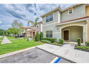 Inviting two-story townhome with a well-manicured lawn and covered front porch at 8962 Sugar Palm Rd, Kissimmee, FL 34747