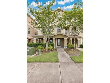 Charming two-story townhouse featuring a covered front porch and well-maintained landscaping at 10566 Green Ivy Ln, Orlando, FL 32832