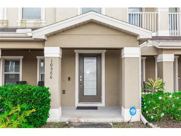 Inviting front entryway with a secure, modern door and well-maintained landscaping at 10566 Green Ivy Ln, Orlando, FL 32832