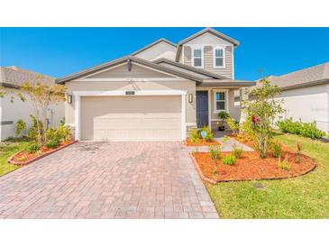 Charming single-Gathering home with a brick driveway, a two-car garage and inviting landscaping at 125 Links Terrace Blvd, Daytona Beach, FL 32124