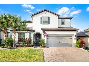 Charming two-story home showcasing a landscaped yard, brick driveway, and a welcoming two-car garage at 1298 Patterson Ter, Lake Mary, FL 32746