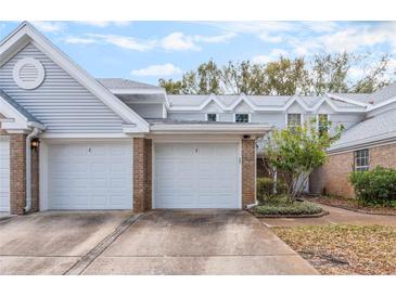 Charming townhome exterior featuring brick accents, multiple garages, and well-maintained landscaping at 2201 Coach House Blvd # 3, Orlando, FL 32812