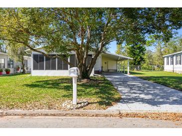 Charming home with a well-manicured lawn, mature tree, and a convenient covered carport at 2706 Cranmoor Dr, Kissimmee, FL 34758