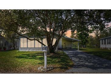 Charming home featuring well-kept lawn, carport and large tree providing shade at 2706 Cranmoor Dr, Kissimmee, FL 34758