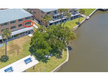 Aerial view of waterfront condo with lush landscaping and community dock at 415 N Halifax Ave # 216, Daytona Beach, FL 32118