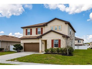 Charming two-story home featuring a two-car garage, manicured lawn and contrasting shutters and trim at 5607 Western Sky Pl, St Cloud, FL 34771