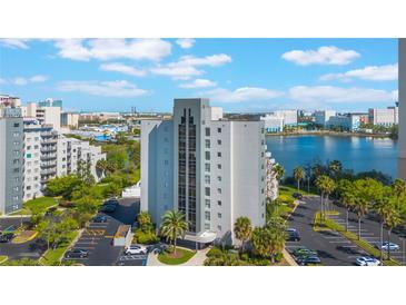 View of exterior of building with parking lot, landscaping, and water view at 6165 Carrier Dr # 1504, Orlando, FL 32819