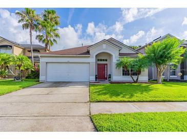Charming single-story home with a well-manicured lawn and a red front door at 1401 Royal Saint George Dr, Orlando, FL 32828