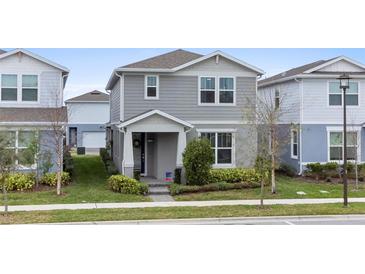 Charming two-story home with a manicured lawn and inviting front porch at 14146 Lanikai Beach Dr, Orlando, FL 32827