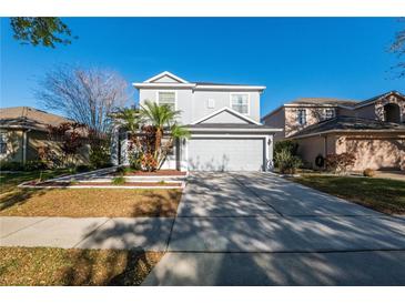 Charming two-story home with a well-manicured front yard and attached two-car garage on a sunny day at 14415 Estrella Dr, Orlando, FL 32837