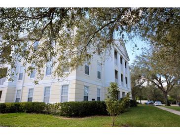 Low angle of white three-story building with landscaping and an inviting covered balcony at 193 Longview Ave # 104, Kissimmee, FL 34747