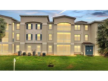 Beautiful exterior view of a multi-story condo building featuring manicured lawns and neutral color scheme at 3301 Whitestone Cir # 204, Kissimmee, FL 34741