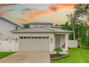 Charming home featuring a grey roof, white exterior, two car garage and beautiful lawn at 350 E 2Nd Ave, New Smyrna Beach, FL 32169