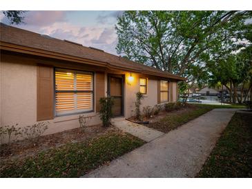 Charming single-story home featuring a well-maintained front yard, pathway, and warm exterior lighting at 385 Eron Way # 45, Winter Garden, FL 34787