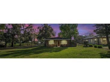 Charming brick home with a lush green lawn and mature trees, offering a serene and inviting curb appeal at 651 W Lake Brantley Rd, Altamonte Springs, FL 32714