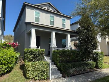 Charming two-story home with a welcoming front porch and well-maintained landscaping at 7853 Summerlake Groves St, Winter Garden, FL 34787