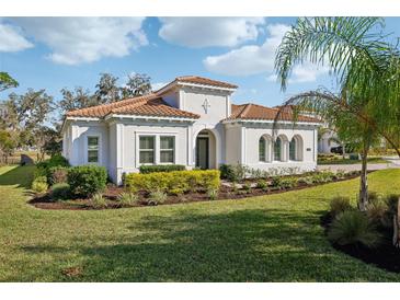 Charming single-story home featuring a terracotta roof, stucco facade, and lush landscaping at 8064 Peaceful Cir, Sanford, FL 32771