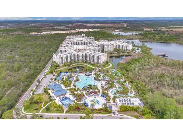 Stunning aerial view of resort featuring a large pool, water slides, and lush landscaping at 14501 Grove Resort Ave # 2522, Winter Garden, FL 34787