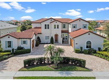 Stunning two-story home with a brick driveway, red tile roof, and elegant landscaping at 15644 Panther Lake Dr, Winter Garden, FL 34787