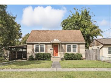 Charming single-story home with a well-manicured lawn, complemented by a quaint orange front door at 1975 Staunton Ave, Winter Park, FL 32789