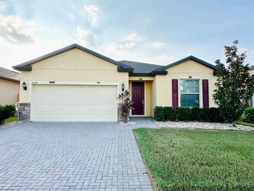 Charming single-story home with a well-manicured lawn and brick paved driveway at 2706 Vermillion Ct, St Cloud, FL 34771