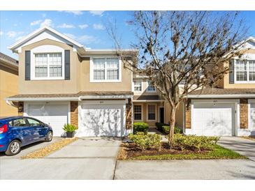 Charming townhome with a one-car garage, front yard landscaping, and neutral color palette at 409 Hilgard Cv # 106, Sanford, FL 32771