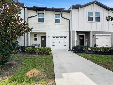 Charming townhome featuring a front yard and a single-car garage, set under a clear blue sky at 532 Madison Dr, Davenport, FL 33837