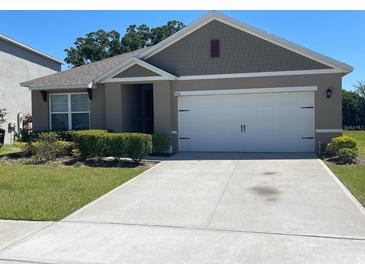 Charming single-story home featuring a well-manicured lawn and a spacious two-car garage at 956 Brooklet Dr, Davenport, FL 33837