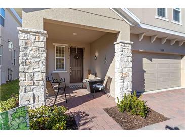 Inviting front porch with stone pillars and a cozy seating area, perfect for relaxing and enjoying the neighborhood at 1129 Blue Garden Dr, Deland, FL 32720