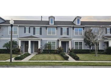 A well-maintained townhome with a landscaped front yard and a symmetrical facade with modern fixtures at 15471 Honeybell Dr, Winter Garden, FL 34787