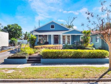 Charming blue home featuring manicured front yard with lush landscaping and inviting curb appeal at 434 E Harding St, Orlando, FL 32806