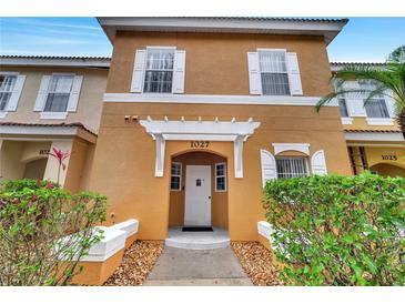 Charming two-story condo with white shutters and landscaped front yard at 1027 Park Ridge Cir, Kissimmee, FL 34746