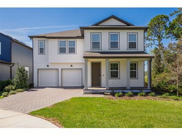 Charming two-story home with a brick driveway, two-car garage, and well-maintained landscaping at 11206 Pixie Mandarin Ct, Winter Garden, FL 34787