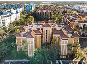 An aerial view of a multi-Gathering complex with a red tile roof surrounded by green trees and other buildings at 12521 Floridays Resort Dr # 307F, Orlando, FL 32821