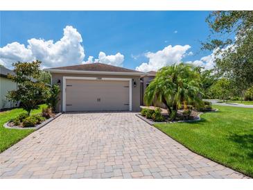 Charming single-story home featuring a two-car garage and a paved driveway with manicured landscaping at 1368 Del Mar Dr, Kissimmee, FL 34759
