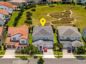 An aerial view of a two-story home featuring well-maintained landscaping and proximity to a neighborhood park at 15724 Cutter Sail Pl, Winter Garden, FL 34787