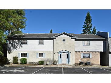 Charming two-story condo with light blue shutters and well-maintained landscaping in a well-lit parking area at 3057 Aaron Burr Ave # 1, Winter Park, FL 32792
