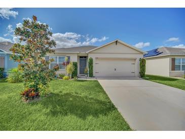 Charming single Gathering home featuring a well-manicured lawn, neutral color palette, and an attached two car garage at 3308 Country Walk Club Cir, Winter Haven, FL 33881
