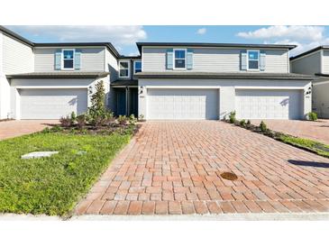 Charming townhomes featuring brick driveways, blue shutters, and well-maintained landscaping at 4365 Switchgrass Ln, St Cloud, FL 34772