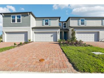 Charming townhome with brick driveway, attached garage, manicured lawn, and delightful curb appeal at 4369 Switchgrass Ln, St Cloud, FL 34772