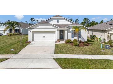 Charming single-Gathering home with a two-car garage, concrete driveway and meticulously maintained lawn at 512 Stowers Dr, New Smyrna Beach, FL 32168