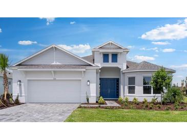 Beautiful, single-story home featuring a 2-car garage, blue front door, manicured lawn, and thoughtfully designed landscaping at 5641 Nevis Ter, Kissimmee, FL 34758