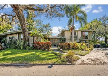 Charming single-Gathering home with mature landscaping, a lush green lawn, and inviting curb appeal at 605 Sweetbriar Rd, Orlando, FL 32806