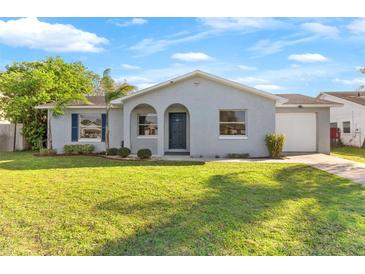 Charming single-story home with a well-manicured lawn and gray exterior paint at 649 Caribou Ct, Poinciana, FL 34759