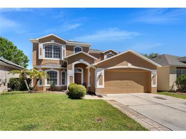 Charming two-story home with a two-car garage, well-maintained lawn, and a welcoming facade at 10033 Hidden Dunes Ln, Orlando, FL 32832