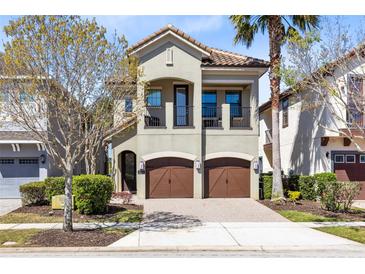 Inviting two-story home boasts a charming balcony and a two-car garage for convenient parking at 1004 Castle Pines Ct, Reunion, FL 34747