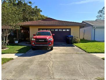 Charming single-story home with a driveway, front yard and a beautiful red Toyota parked at 10223 Marco Polo Dr, Orlando, FL 32821
