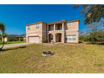 Charming two-story home with a spacious front yard, covered entryway, and attached two-car garage at 1905 Snapper Dr, Kissimmee, FL 34759