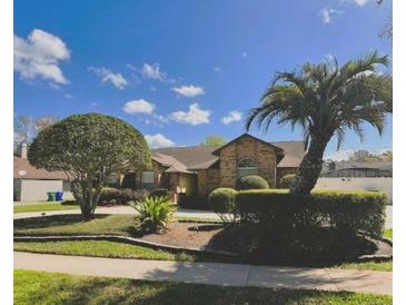 Beautiful single-story brick home with a well-manicured lawn, mature trees, and a welcoming entrance at 202 Shady Oaks Cir, Lake Mary, FL 32746